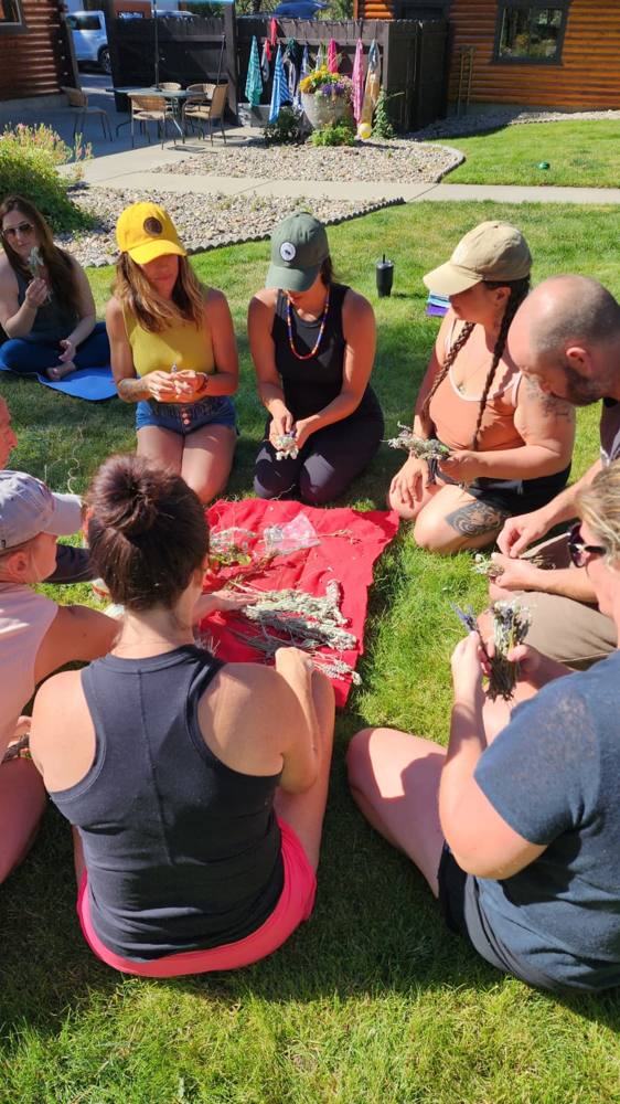A group sitting outdoors working with plants